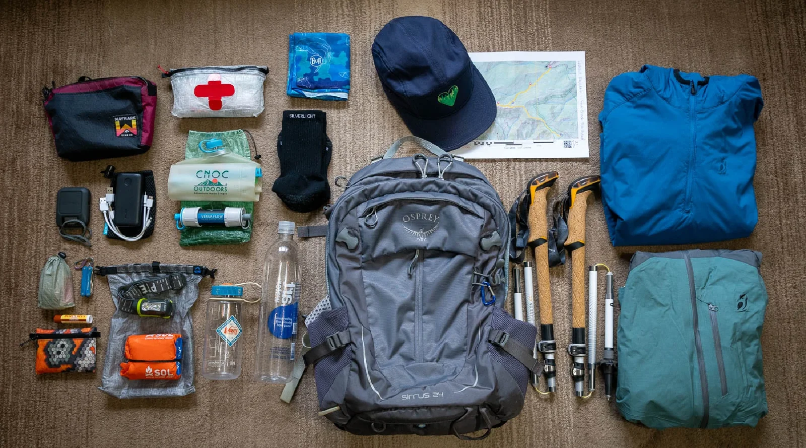 Colección de equipo de viaje o para actividades al aire libre, incluyendo una mochila, mapas y más.